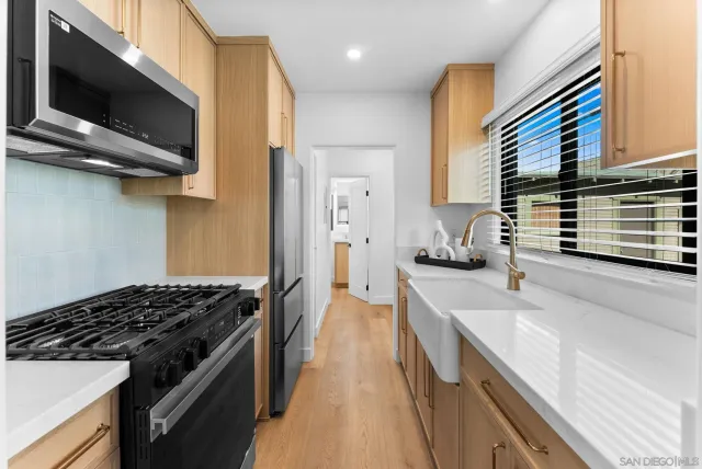 a kitchen with stainless steel appliances granite countertop a sink and a stove