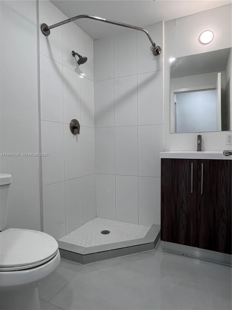 14559 Southwest 261st Street, Unit 14559 Homestead, FL 33032 - Photo 2 of 15 a bathroom with a shower a toilet and a sink