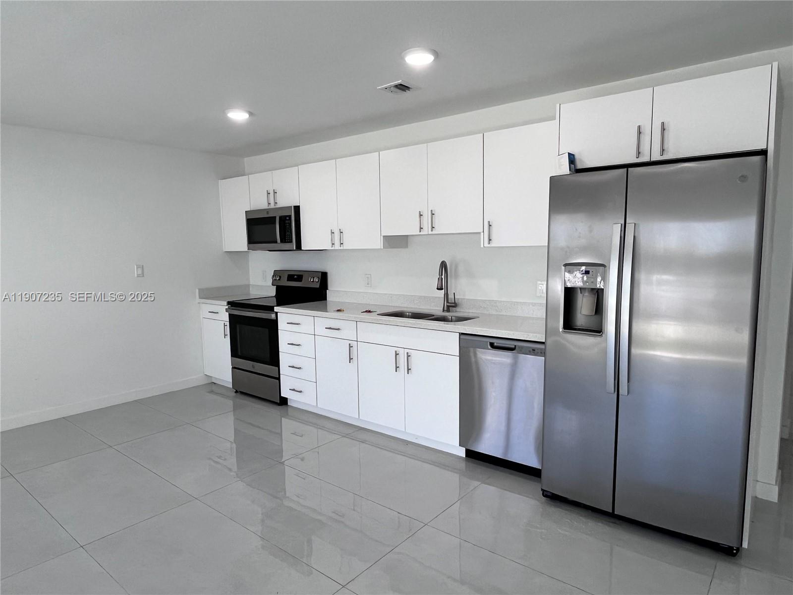 14559 Southwest 261st Street, Unit 14559 Homestead, FL 33032 - Photo 8 of 15 a kitchen with a refrigerator sink and microwave