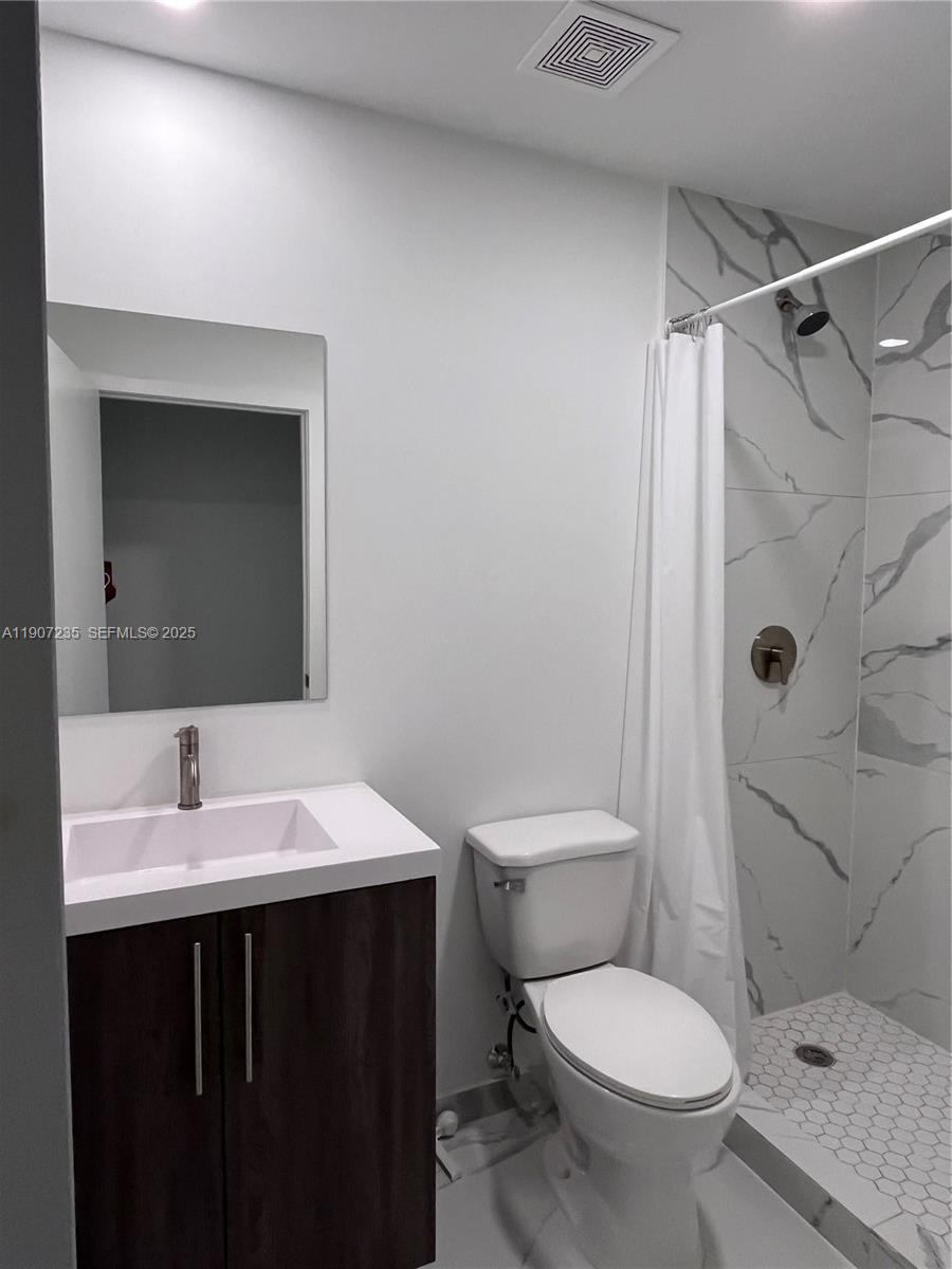 14559 Southwest 261st Street, Unit 14559 Homestead, FL 33032 - Photo 10 of 15 a bathroom with a sink toilet and shower