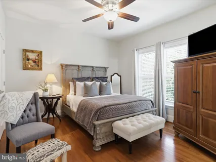 a bedroom with a large bed a flat tv screen and dresser