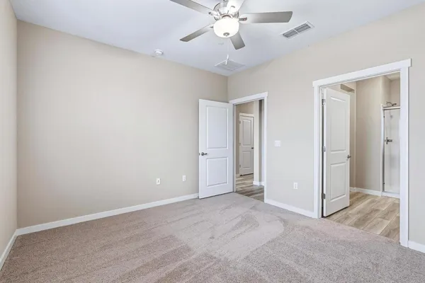 an empty room with fan and entrance