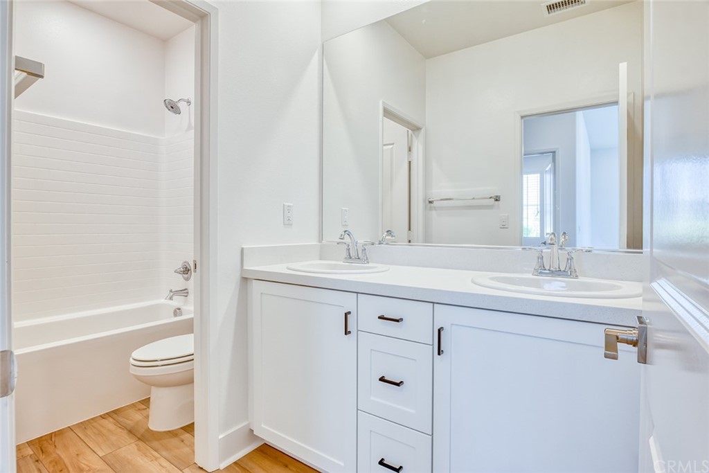 5603 Kate Way Fontana, CA 92336 - Photo 17 of 63 a bathroom with a granite countertop toilet a sink and a bathtub