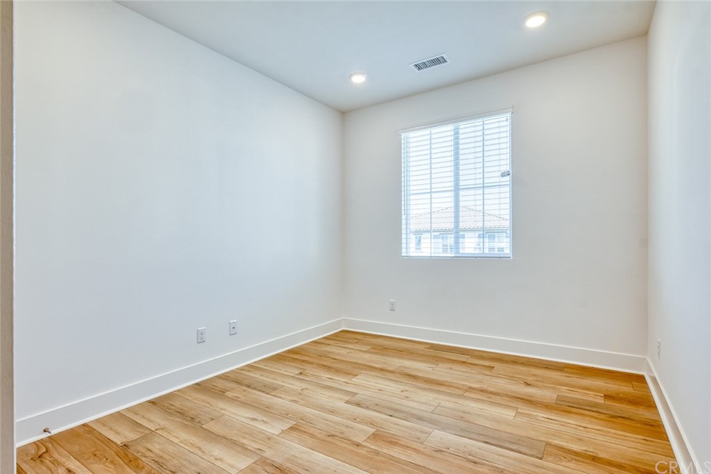 5603 Kate Way Fontana, CA 92336 - Photo 18 of 63 an empty room with wooden floor and windows