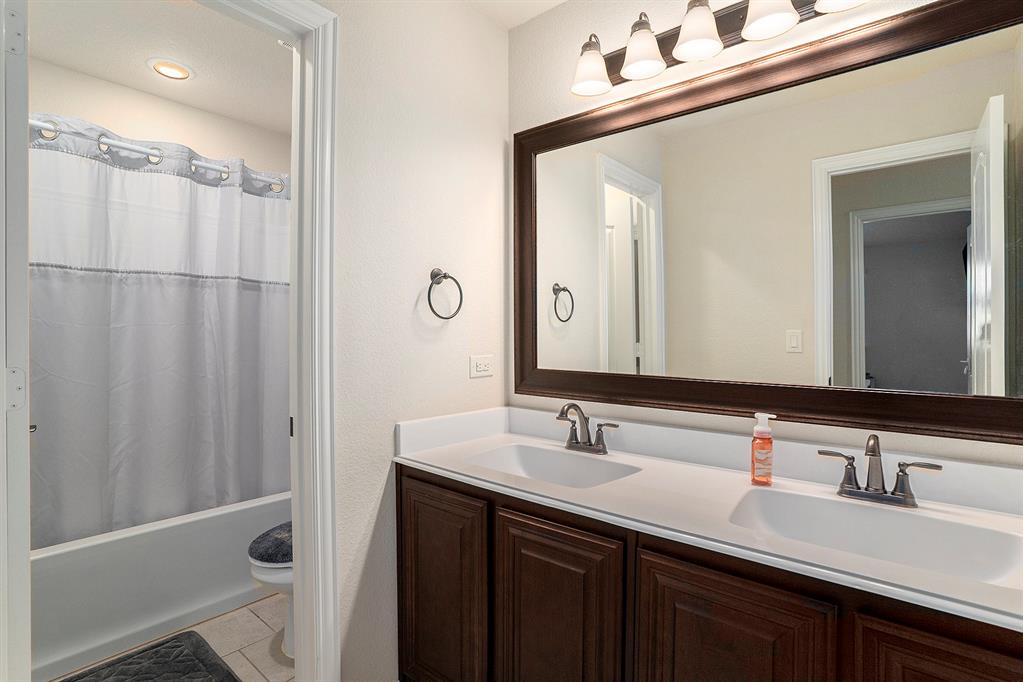 1076 Imperial Eagle Road Alvarado, TX 76009 - Photo 28 of 32 a bathroom with a double vanity sink and mirror