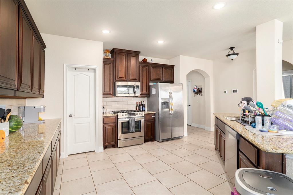 1076 Imperial Eagle Road Alvarado, TX 76009 - Photo 8 of 32 a kitchen with stainless steel appliances granite countertop a sink stove and refrigerator