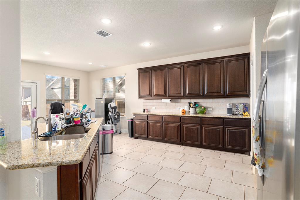 1076 Imperial Eagle Road Alvarado, TX 76009 - Photo 10 of 32 a kitchen with granite countertop a sink stove and cabinets
