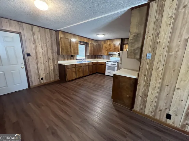 a view of a kitchen with wooden floor and electronic appliances