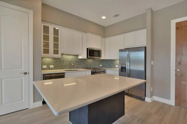 a kitchen with a refrigerator a sink and wooden floor