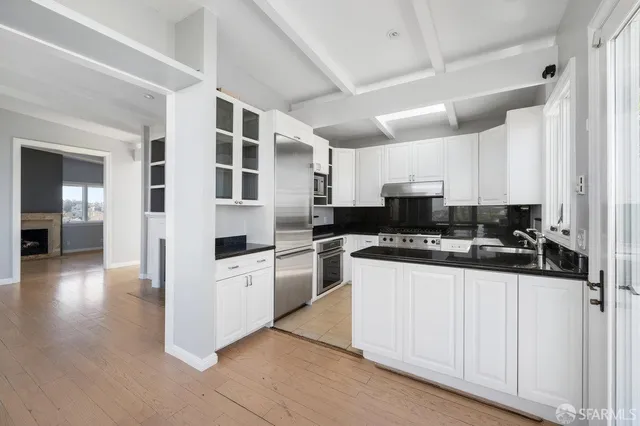 a view of an empty room with a fireplace and a window