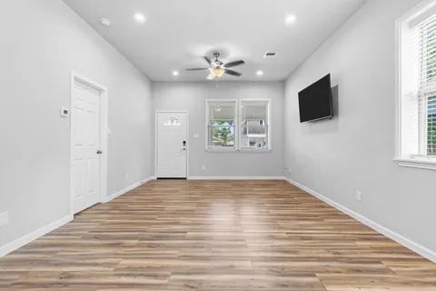a view of a kitchen with kitchen island stainless steel appliances wooden floor stove kitchen island and windows