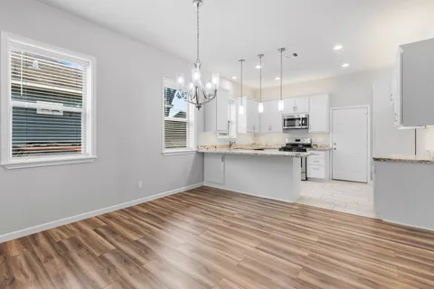 a kitchen with stainless steel appliances granite countertop a sink a stove and a refrigerator