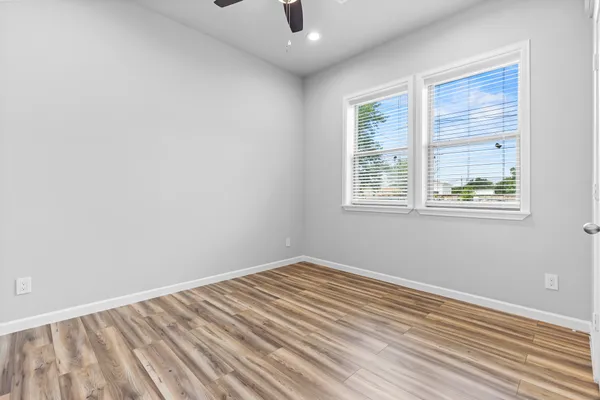 a view of an empty room with wooden floor