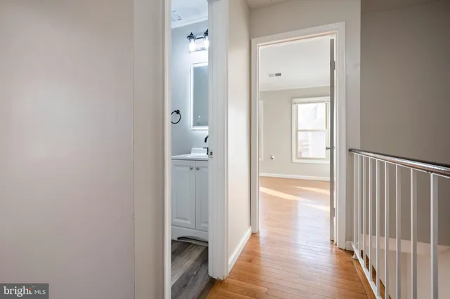 an empty room with wooden floor fireplace and windows