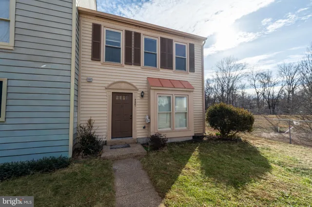 a view of a backyard with wooden fence and large trees