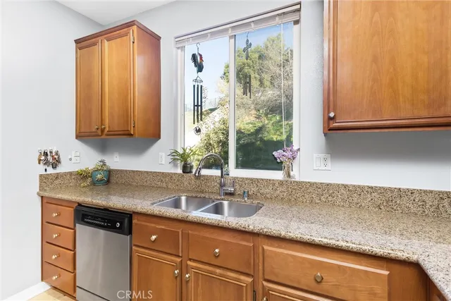 a kitchen with stainless steel appliances granite countertop a stove top oven a refrigerator a sink and a microwave