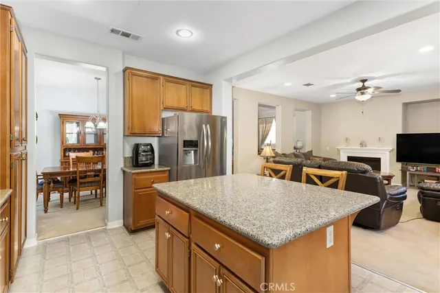 a kitchen with granite countertop wooden cabinets dining table and stainless steel appliances