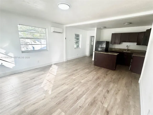 a view of kitchen with wooden floor and electronic appliances