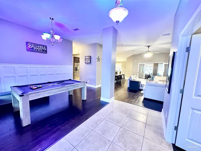 a living room with furniture kitchen view and a chandelier