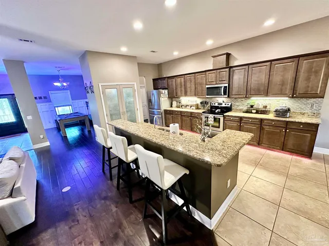 a living room with bed furniture and a flat tv screen