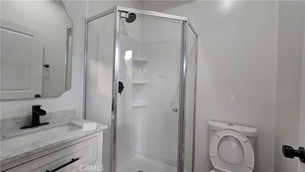 a bathroom with a granite countertop sink toilet and shower