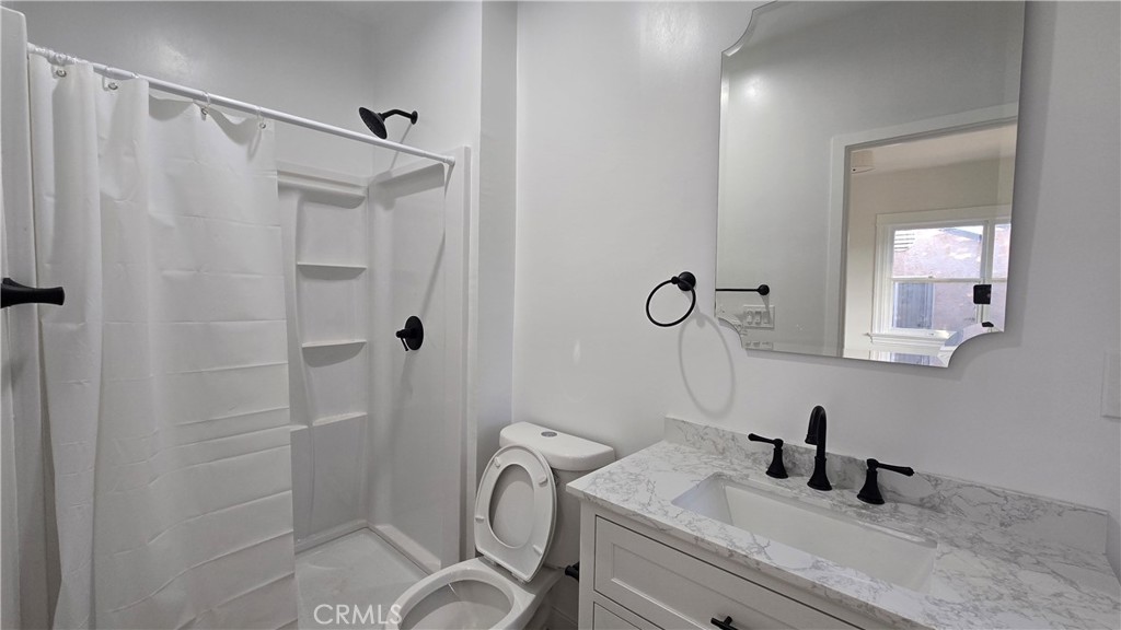 1038 Beacon Avenue, Unit 1038 Los Angeles, CA 90015 - Photo 9 of 9 a bathroom with a sink a toilet and shower