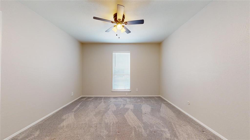 7700 Chapin Road, Unit 5 Fort Worth, TX 76116 - Photo 10 of 12 Neutral wall paint, ceiling fan with light fixture, window with blinds, and patterned carpet flooring