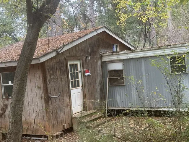a wooden house with a tree in the background
