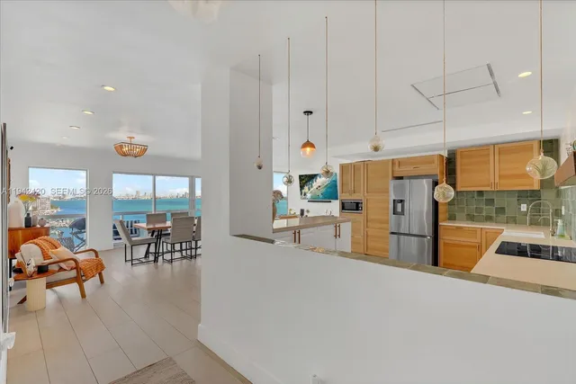 a living room with furniture a flat screen tv and a floor to ceiling window