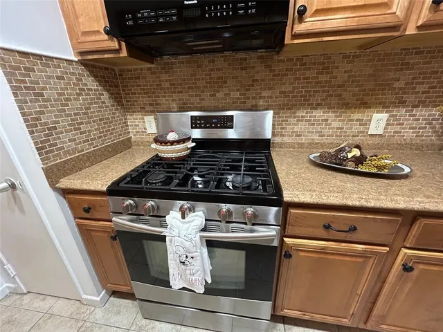 a stove top oven sitting inside of a kitchen