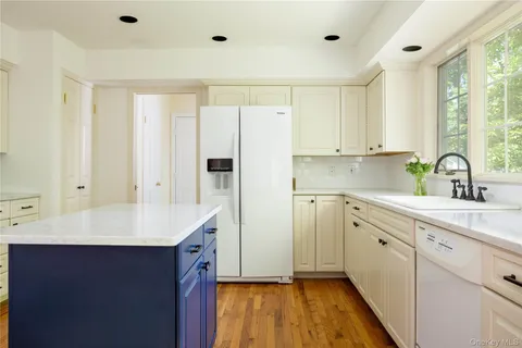 a kitchen with a sink cabinets stainless steel appliances and a window