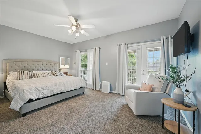 a bedroom with a large bed a flat screen tv and a couch