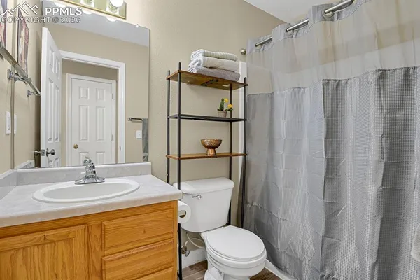 a bathroom with a sink a toilet a mirror and shower curtain