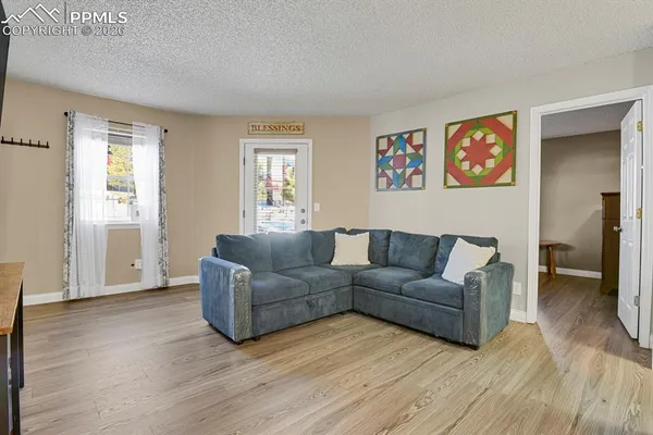 a living room with couches and a view of kitchen