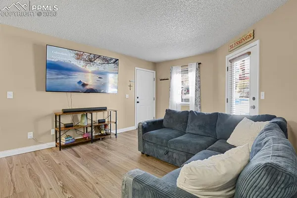 a living room with furniture and a wooden floor