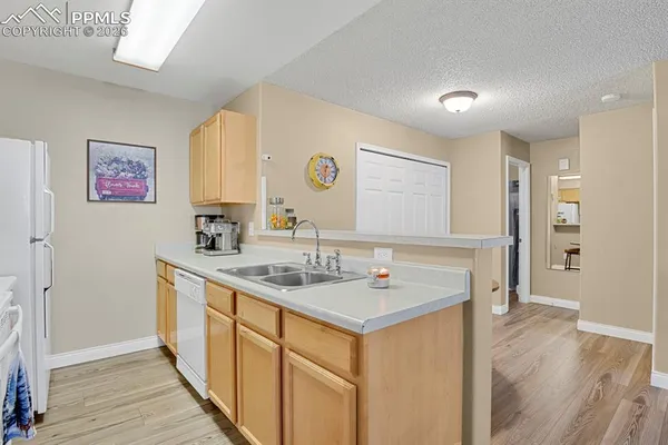 a view of a kitchen with a sink and a refrigerator