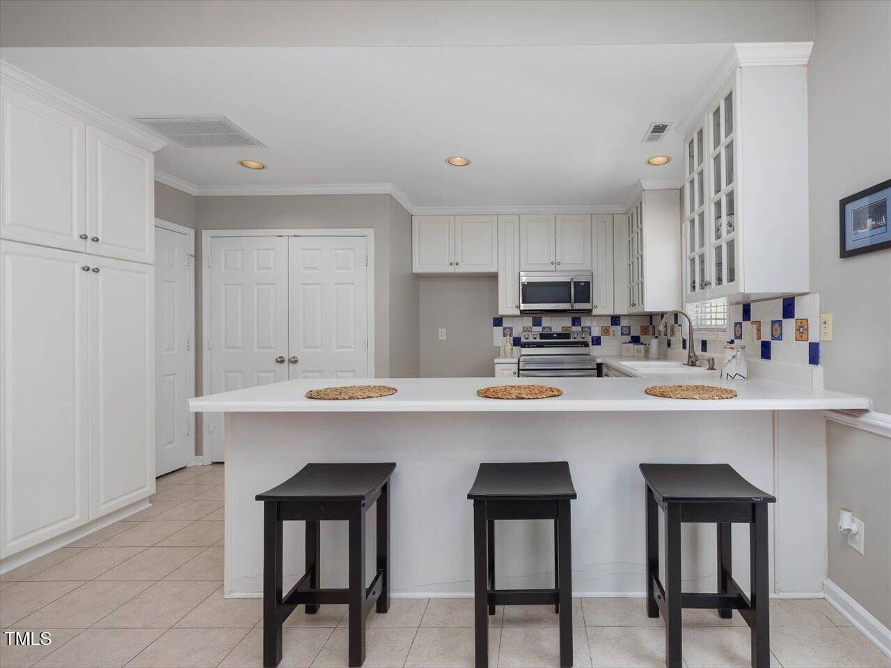 2021 Rivergate Road, Unit 102 Raleigh, NC 27614 - Photo 13 of 42 a kitchen with stainless steel appliances a sink and cabinets