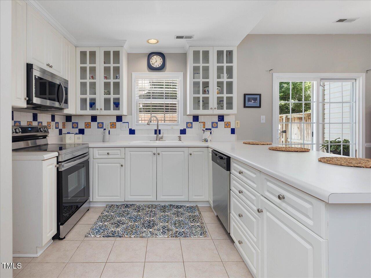 2021 Rivergate Road, Unit 102 Raleigh, NC 27614 - Photo 14 of 42 a kitchen with stainless steel appliances a stove sink and microwave