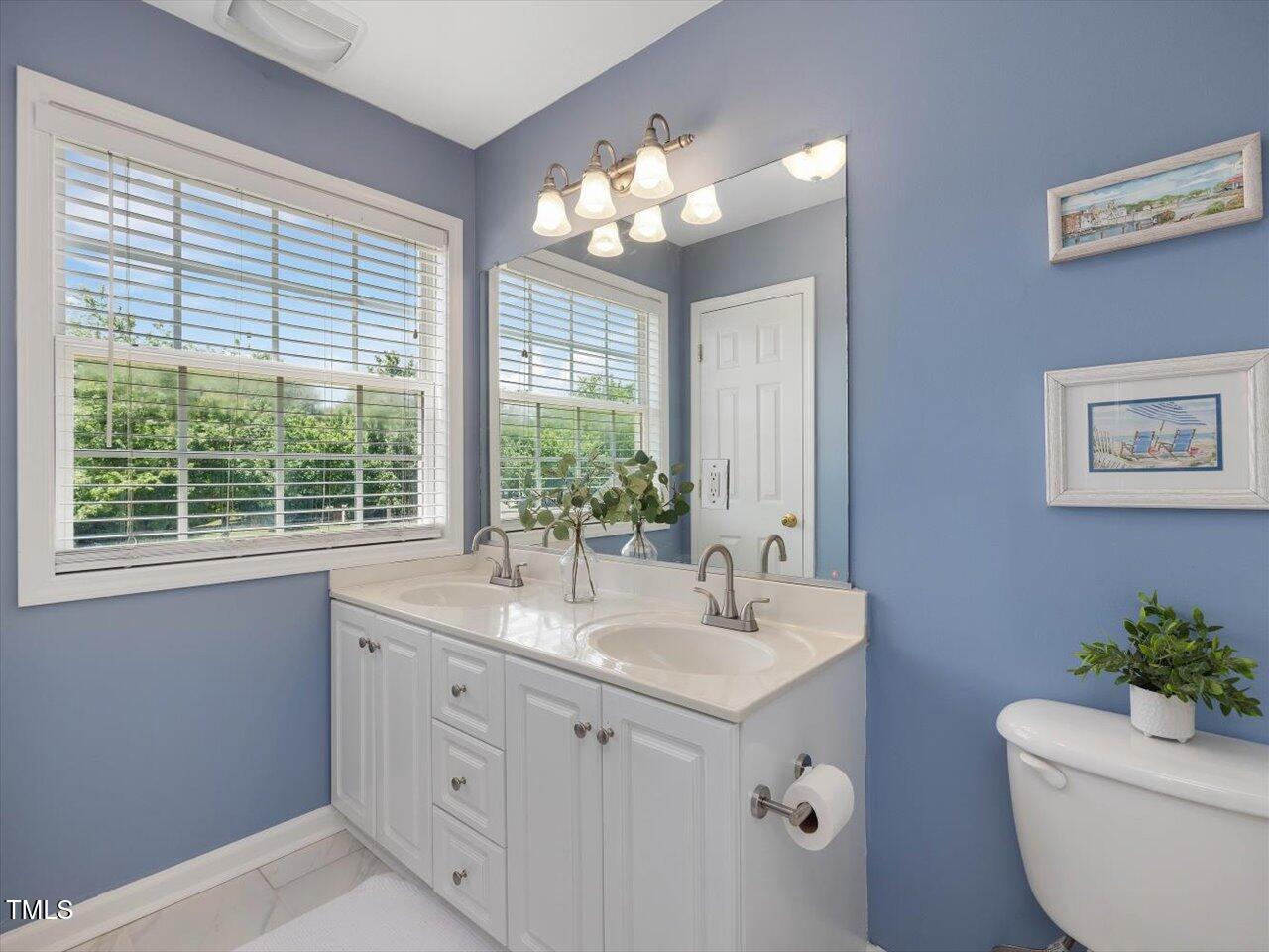 2021 Rivergate Road, Unit 102 Raleigh, NC 27614 - Photo 26 of 42 a bathroom with a toilet sink and mirror