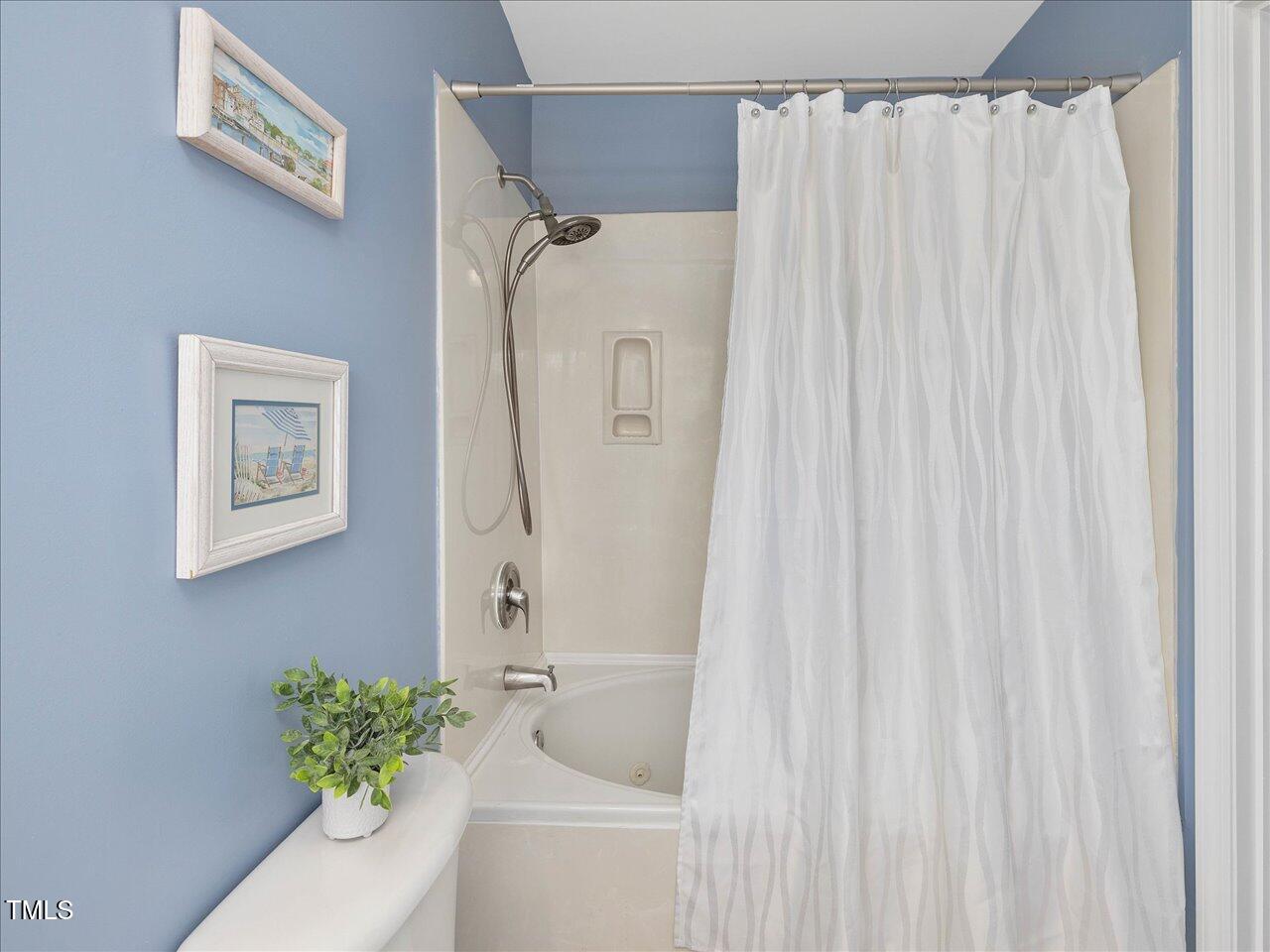 2021 Rivergate Road, Unit 102 Raleigh, NC 27614 - Photo 27 of 42 a bath room with a shower curtain and a sink