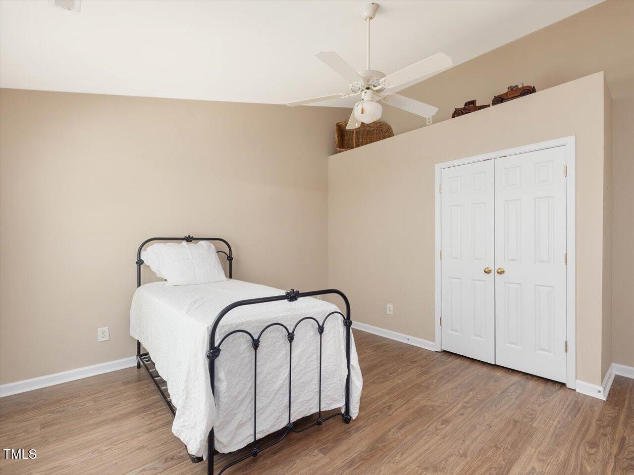 2021 Rivergate Road, Unit 102 Raleigh, NC 27614 - Photo 30 of 42 a bedroom with a bed and wooden floor