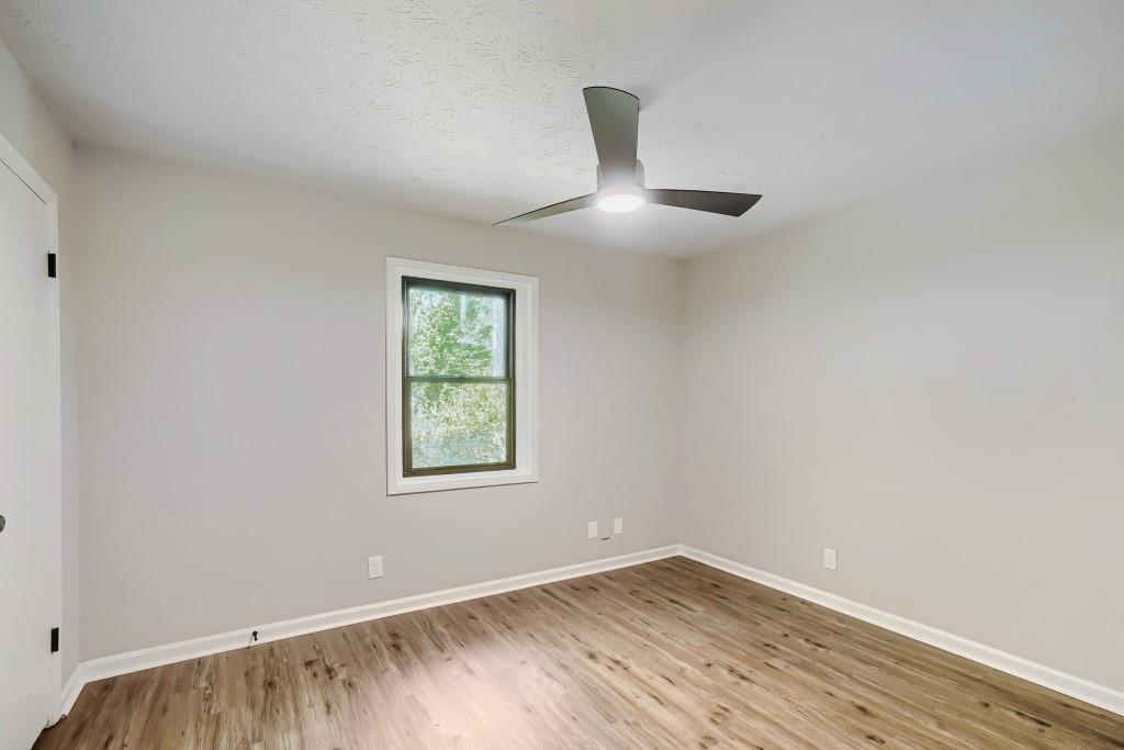 2021 Irwin Bridge Road Northwest Conyers, GA 30012 - Photo 34 of 43 an empty room with wooden floor and windows