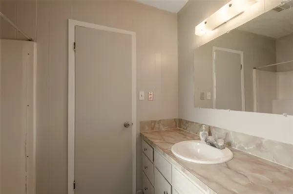 a bathroom with a granite countertop sink and a mirror