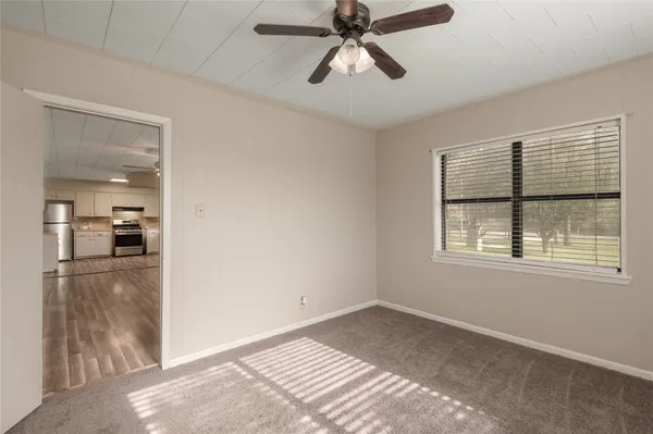 a view of empty room with wooden floor and window