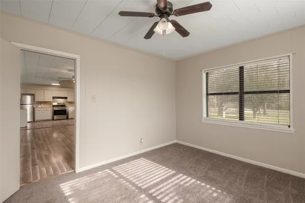 a view of empty room with wooden floor and window