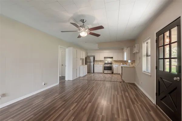 a view of a kitchen with wooden floor and a window