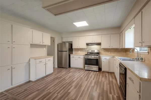 a kitchen with granite countertop white cabinets and stainless steel appliances