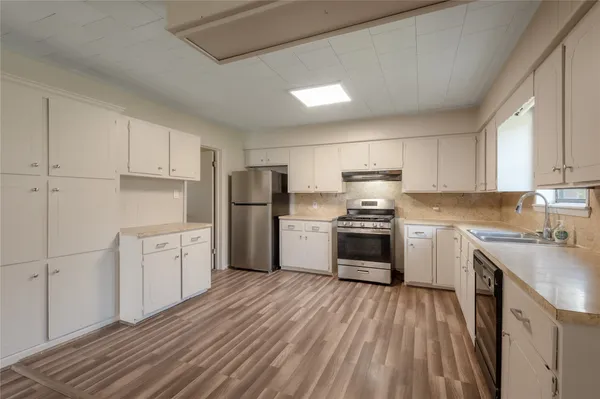 a kitchen with granite countertop white cabinets and stainless steel appliances