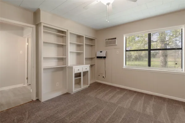 a view of a livingroom with an empty space & a window