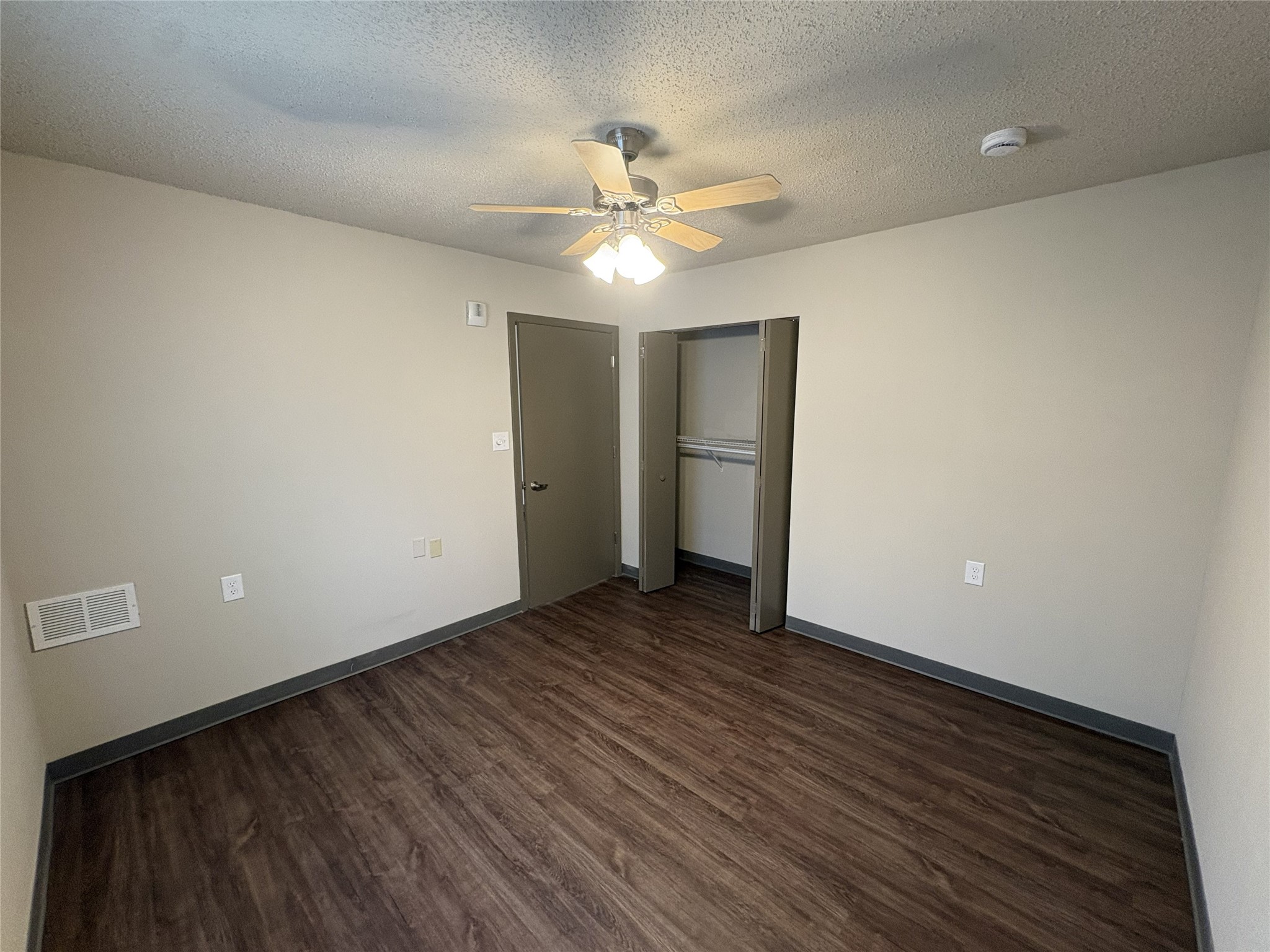 1700 Park Street Beatrice, NE 68310 - Photo 17 of 25 a view of an empty room with wooden floor and a ceiling fan